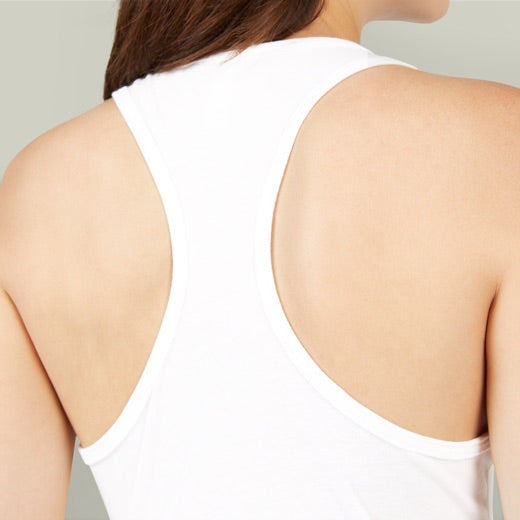 Person wearing a white tank top with a neutral background