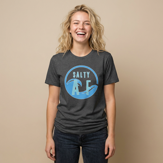 Person wearing a gray t-shirt  with 'SALTY AF' text and stylized ocean graphic design - Island Drops t-shirt collection | Unisex t-shirts