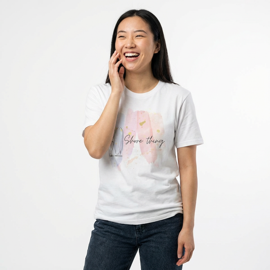 Woman wearing a white t-shirt  with 'Shore Thing' text and watercolor and surfer girl graphic design - Island Drops t-shirt collection | Unisex t-shirts