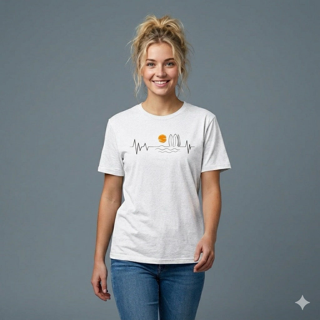 Person wearing a white t-shirt with sunset heartbeat graphic design with surfboards and ocean graphics - Island Drops t-shirt collection | Unisex t-shirts