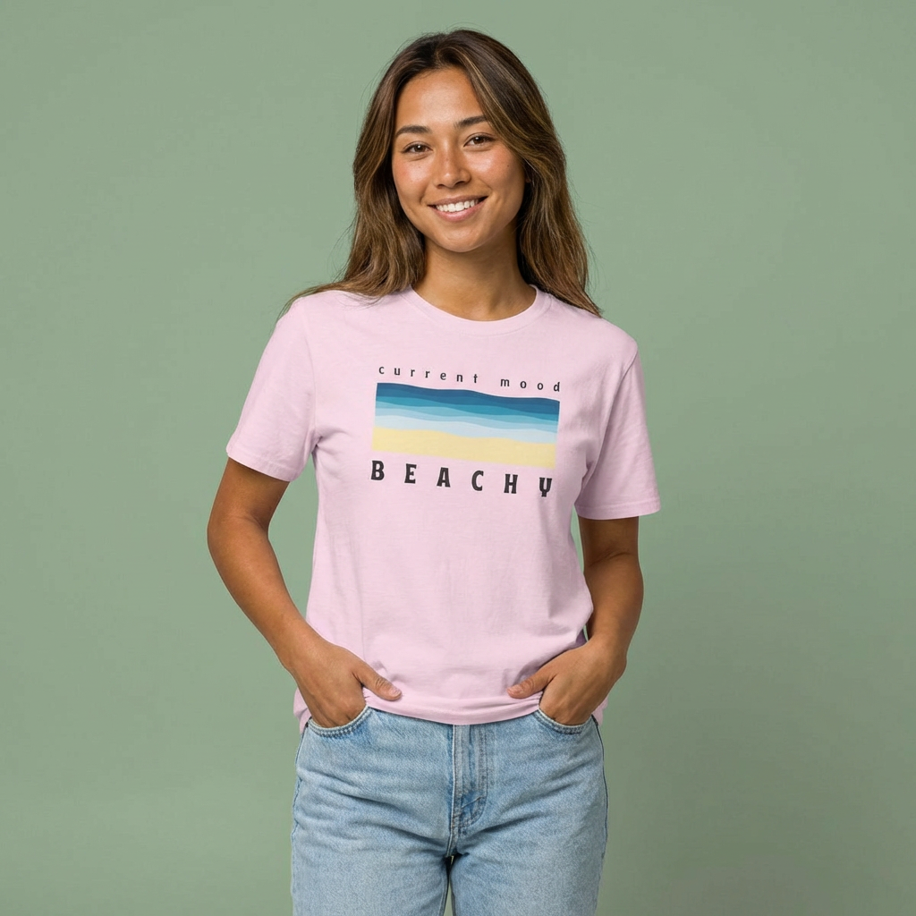 Person wearing a pink t-shirt with 'Current Mood Beachy' design with a stylized beach and ocean graphic design - Island Drops t-shirt collection | Unisex t-shirts