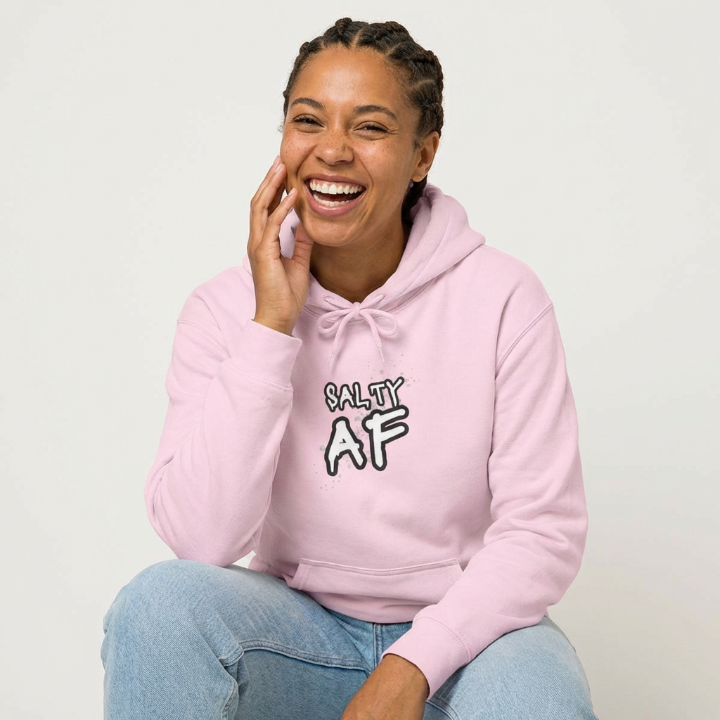 Person wearing a pink hoodie with 'SALTY AF' text graphic design - Island Drops hoodie collection | Unisex pullover