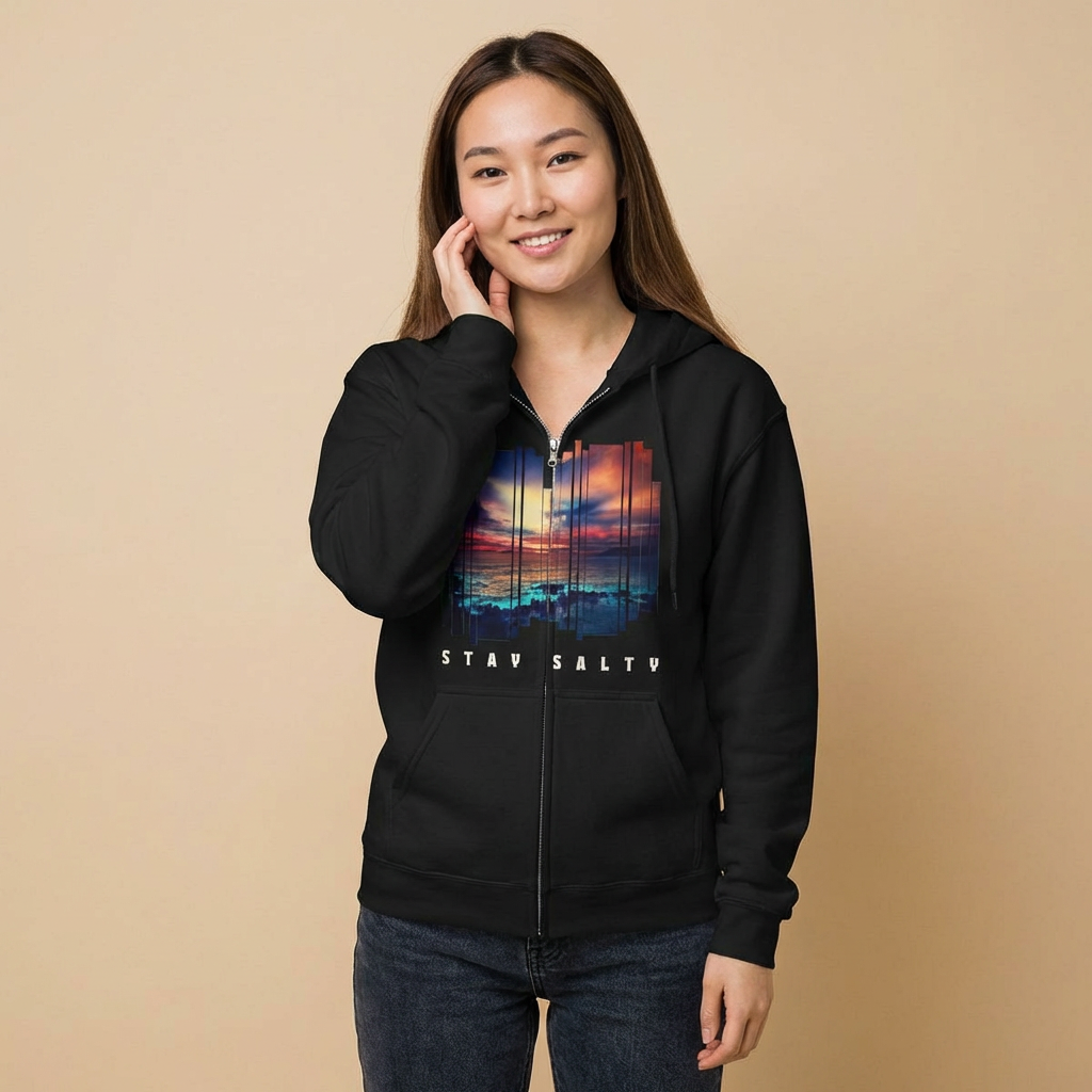 Person wearing a black full zip hoodie with a stylized sunset design and 'STAY SALTY' text - Island Drops hoodie collection | Unisex zipper hoodie