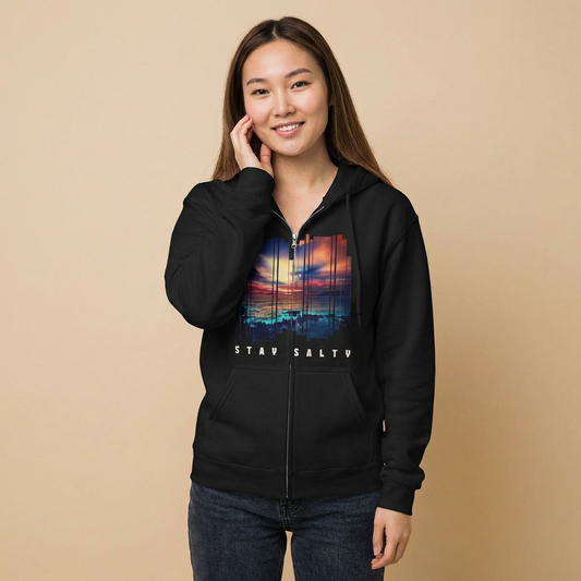 Person wearing a black full zip hoodie with a stylized sunset design and 'STAY SALTY' text - Island Drops hoodie collection | Unisex zipper hoodie