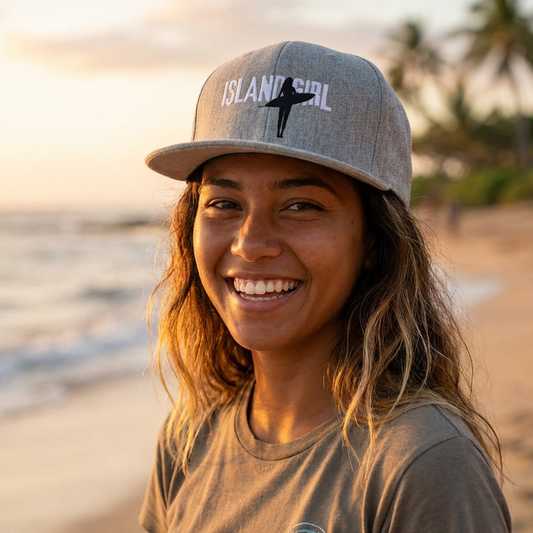 Woman wearing a cap with 'ISLAND GIRL' text and a surfer girl graphic design - Island Drops hat collection | Unisex snapback cap