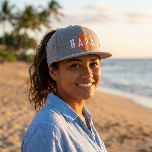Person wearing a 'HAPA' hat with stylized sunset graphic design - Island Drops hat collection | Unisex snapback cap