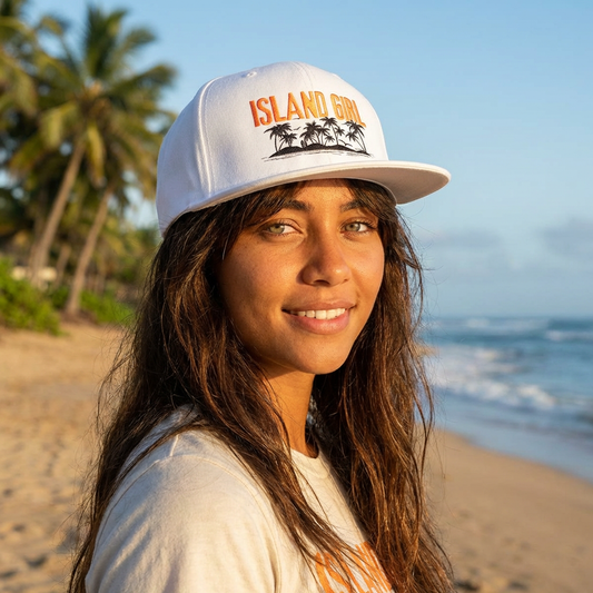 Person wearing a white cap with 'ISLAND GIRL' text and palm trees and island graphic design - Island Drops hat collection | Unisex snapback cap