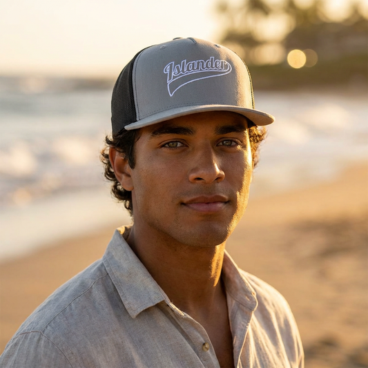 Man wearing a cap with 'Islander' logo on a beach at sunset - Island Drops hat collection | Unisex trucker hat trucker cap